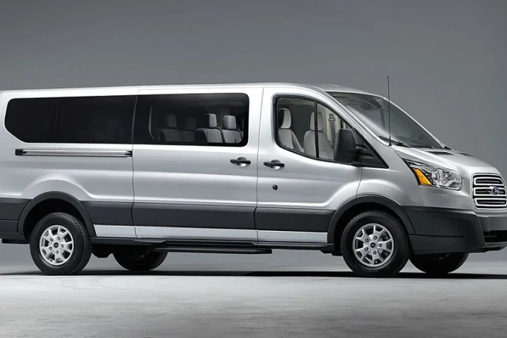 Silver passenger van viewed from side against a gray background.