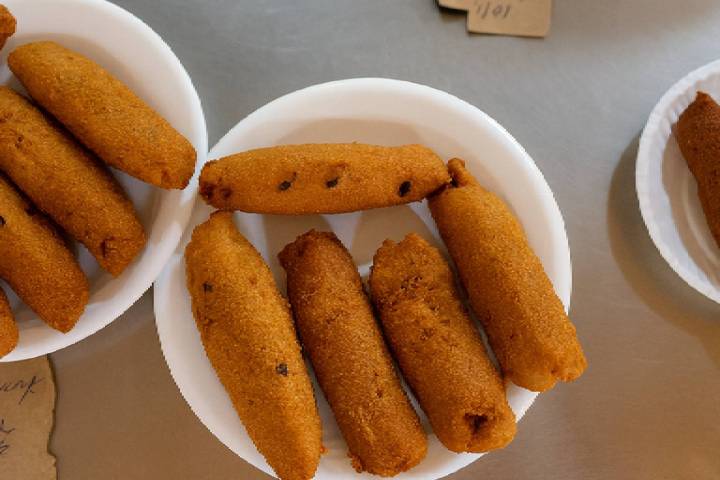 Plates of deep-fried, cylindrical snacks arranged on a table.